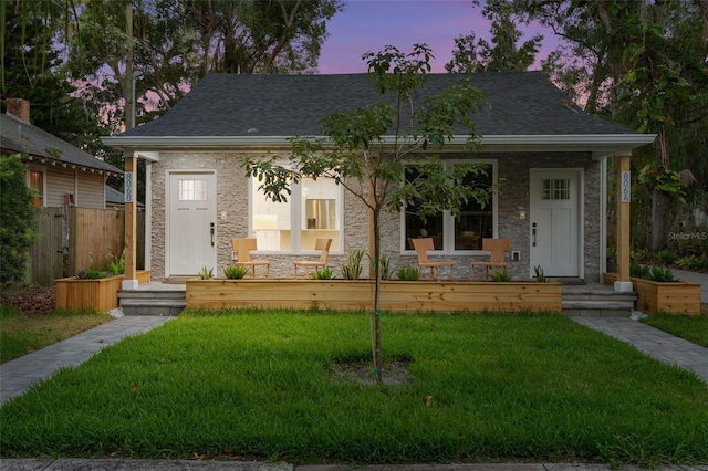 view of front of house with a porch and a yard