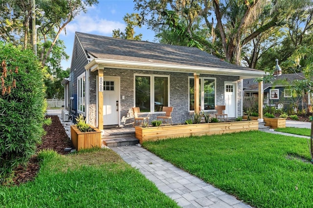 bungalow-style home with a front yard and covered porch