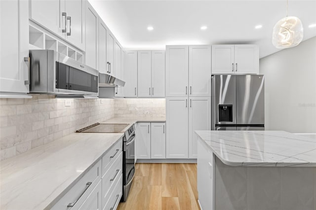 kitchen featuring light stone counters, light hardwood / wood-style floors, white cabinets, and appliances with stainless steel finishes