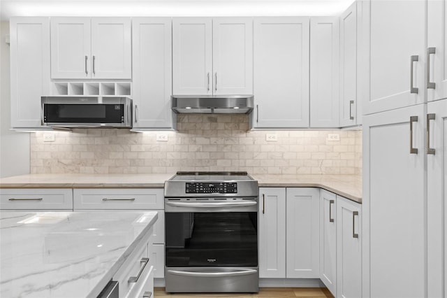 kitchen with light stone counters, appliances with stainless steel finishes, and white cabinets