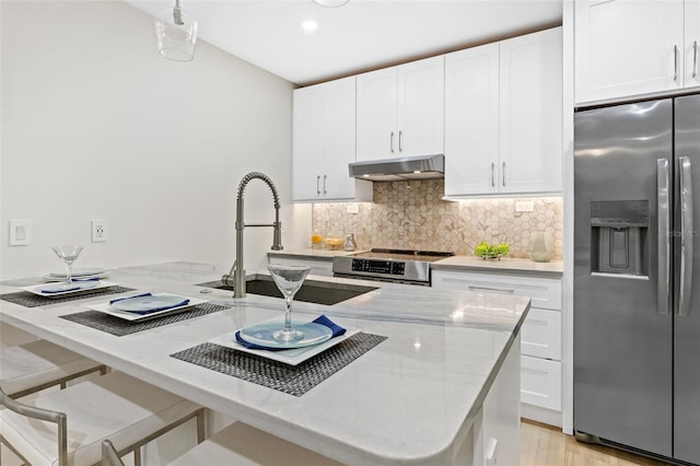 kitchen with white cabinetry, sink, light stone counters, and stainless steel appliances