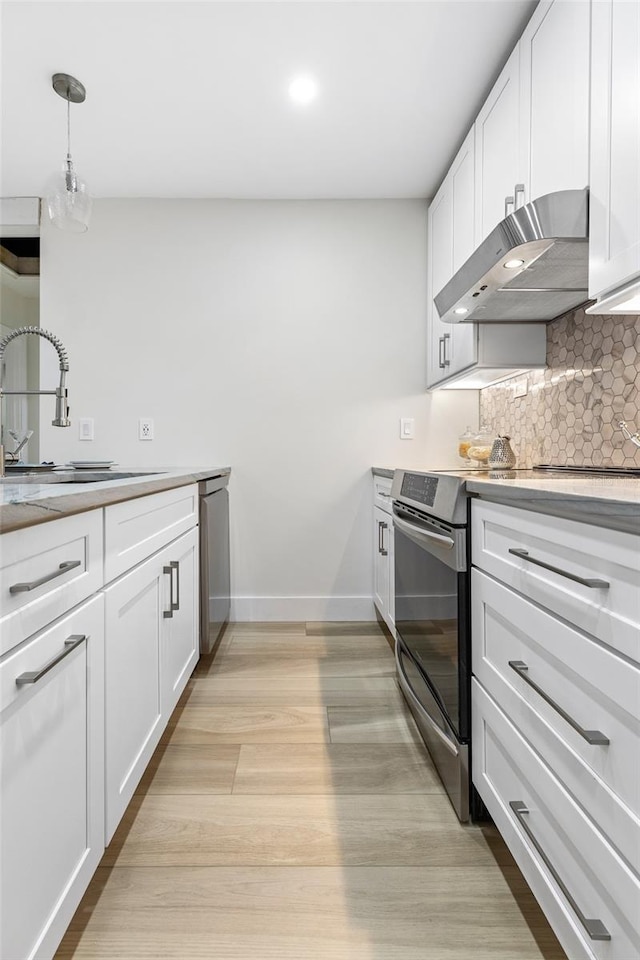 kitchen with sink, white cabinetry, ventilation hood, hanging light fixtures, and appliances with stainless steel finishes