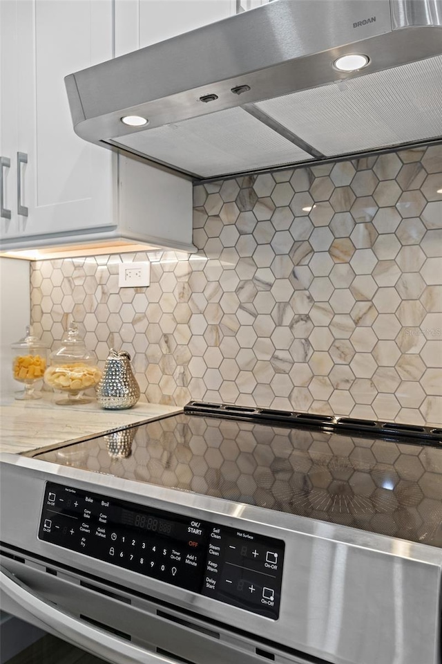 kitchen with white cabinetry, decorative backsplash, electric range, and range hood