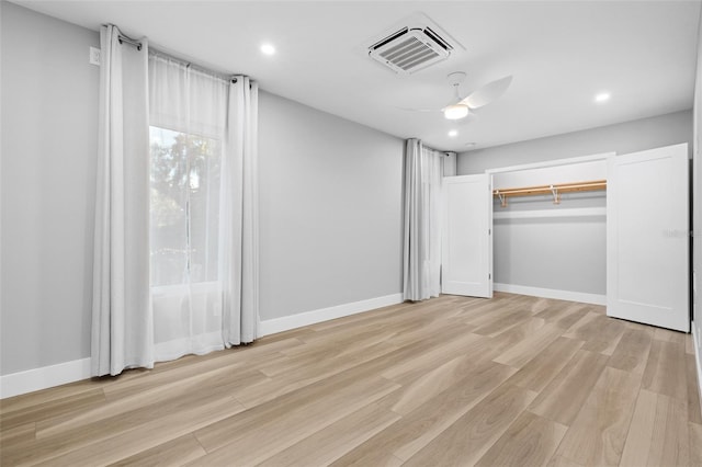 unfurnished bedroom with light hardwood / wood-style floors, ceiling fan, and a closet