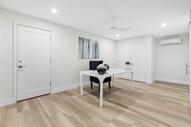 home office featuring ceiling fan, a wall mounted air conditioner, and light hardwood / wood-style floors