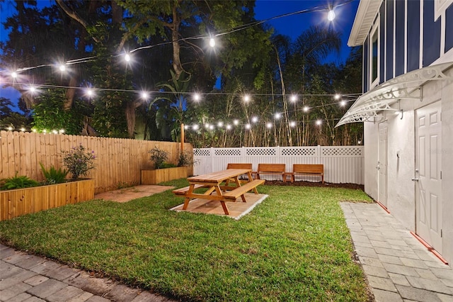 yard at night featuring a patio