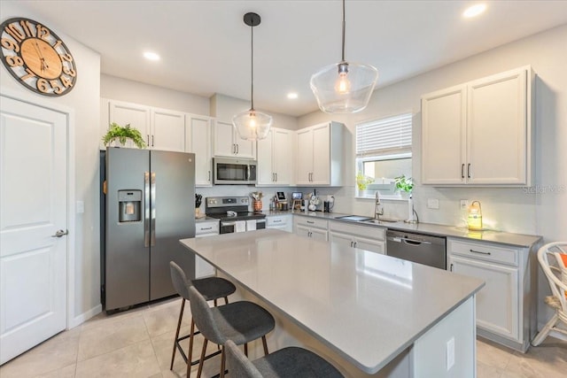 kitchen with a kitchen island, pendant lighting, white cabinetry, sink, and stainless steel appliances