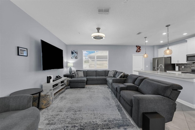 living room with light tile patterned flooring and a textured ceiling