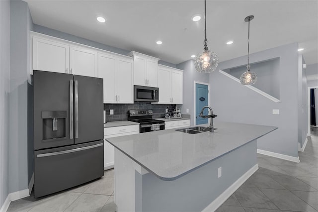 kitchen featuring sink, stainless steel appliances, white cabinets, and a center island with sink