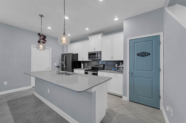 kitchen with stainless steel appliances, decorative light fixtures, a center island with sink, and white cabinets