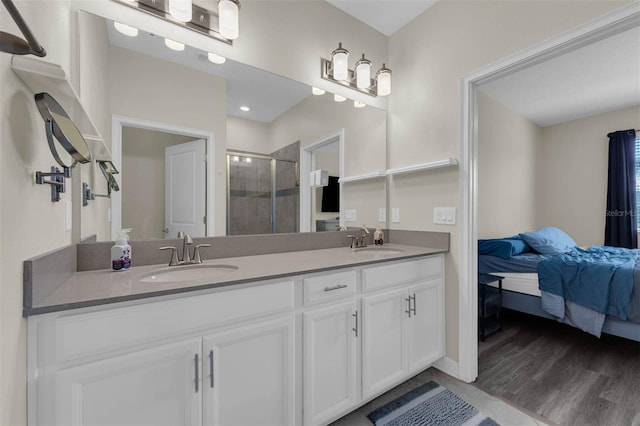 bathroom with hardwood / wood-style flooring, vanity, and an enclosed shower