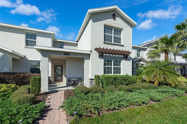 view of front of house with a pergola and stucco siding