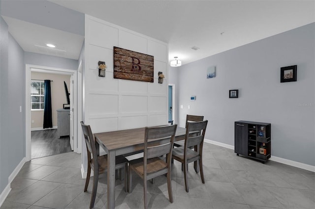 dining room with light tile patterned floors, visible vents, and baseboards