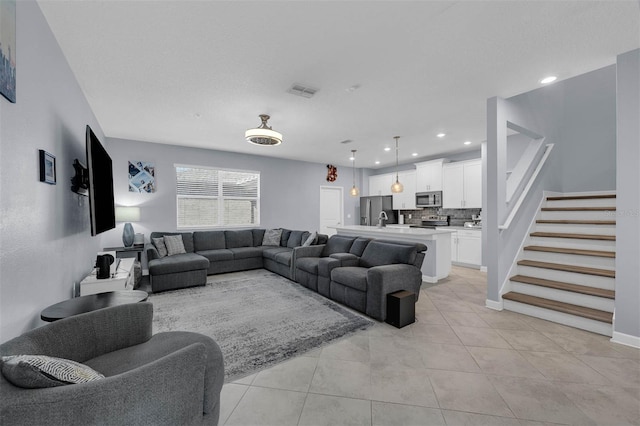 living area with stairway, light tile patterned flooring, recessed lighting, and baseboards