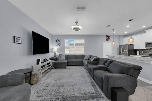 living room featuring light tile patterned floors, visible vents, recessed lighting, and a textured ceiling