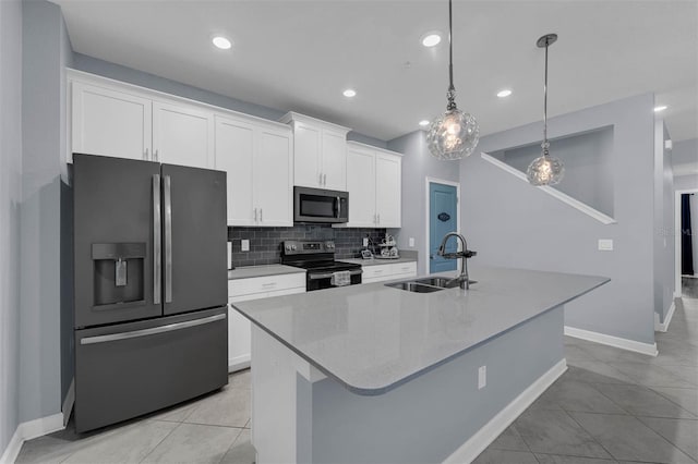 kitchen featuring a kitchen island with sink, a sink, tasteful backsplash, white cabinetry, and stainless steel appliances