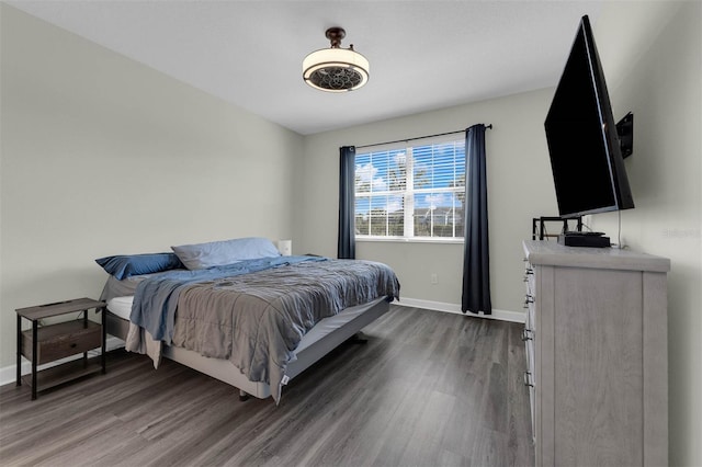 bedroom featuring baseboards and dark wood-style flooring