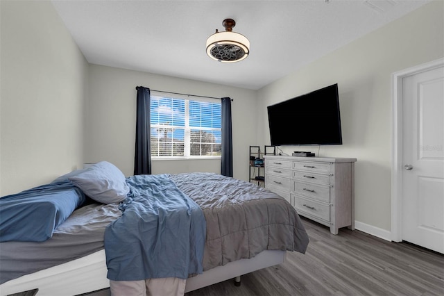 bedroom with visible vents, baseboards, and wood finished floors