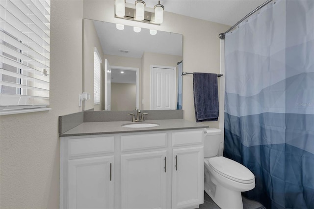 bathroom with toilet, vanity, and a shower with curtain