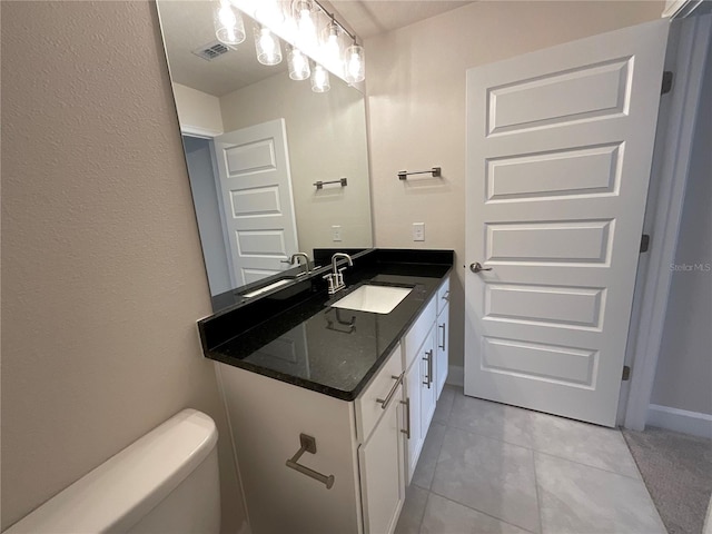 bathroom featuring tile patterned flooring, vanity, and toilet