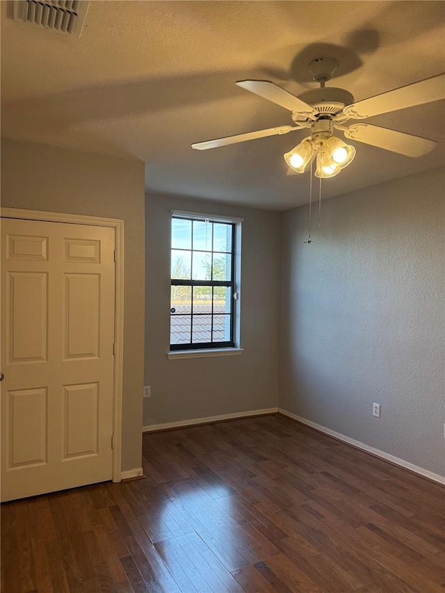 unfurnished room with ceiling fan and dark hardwood / wood-style flooring