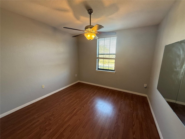 spare room with ceiling fan, dark hardwood / wood-style floors, and a textured ceiling