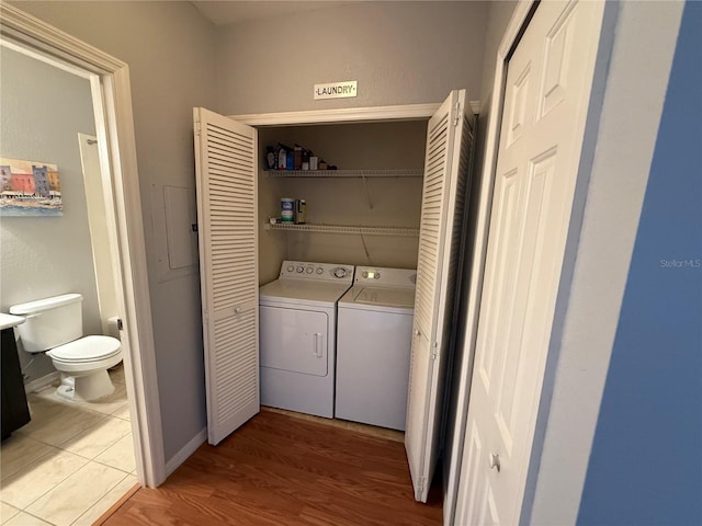 washroom with washing machine and dryer and light wood-type flooring