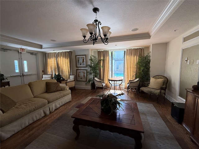 living room featuring dark hardwood / wood-style flooring, a tray ceiling, a wealth of natural light, and crown molding