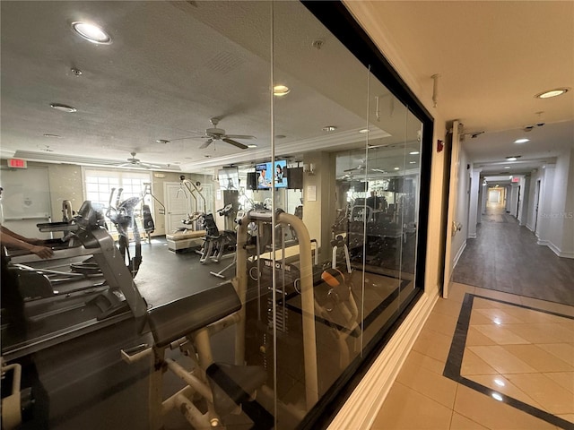 exercise room featuring crown molding, ceiling fan, and tile patterned flooring