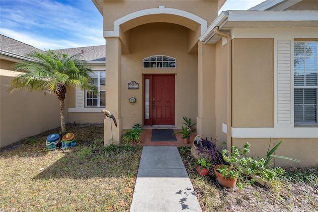 doorway to property featuring stucco siding