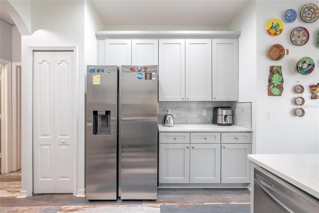 kitchen featuring backsplash, hardwood / wood-style flooring, and appliances with stainless steel finishes