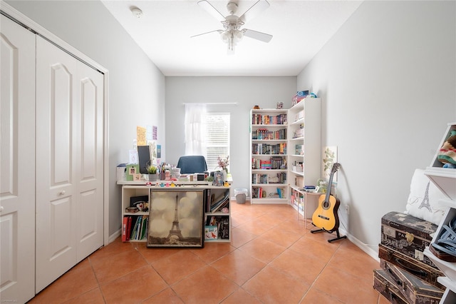 office with light tile patterned floors, a ceiling fan, and baseboards