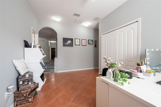 interior space featuring visible vents, arched walkways, baseboards, and light tile patterned flooring