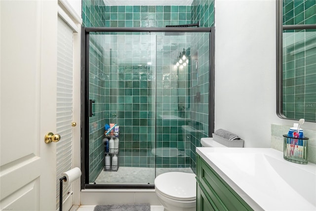 full bath featuring a stall shower, vanity, and toilet