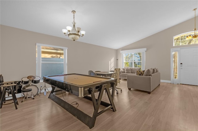 recreation room with lofted ceiling, a chandelier, and light wood-type flooring