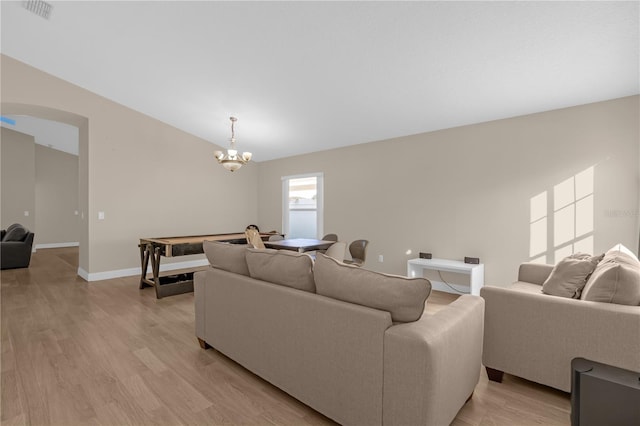 living room with a notable chandelier and light hardwood / wood-style floors