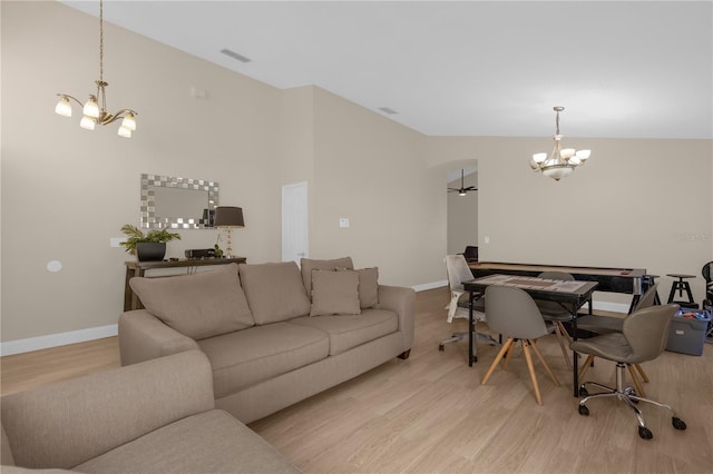 living room with light hardwood / wood-style floors and a notable chandelier