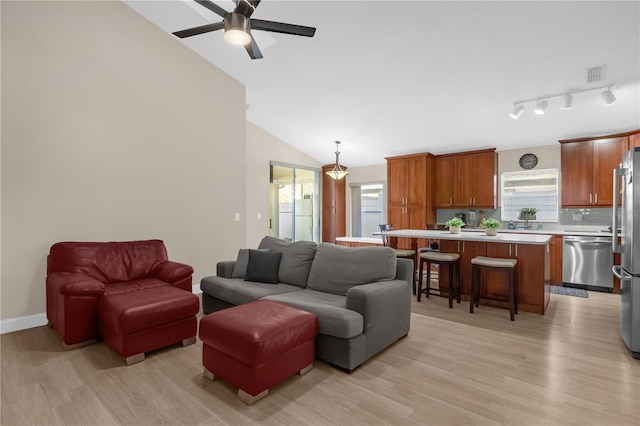 living room featuring vaulted ceiling, light hardwood / wood-style floors, and ceiling fan