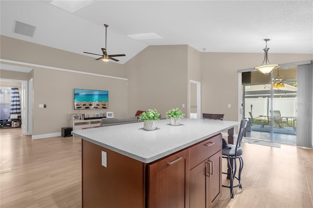 kitchen with a kitchen island, pendant lighting, lofted ceiling, ceiling fan, and light wood-type flooring