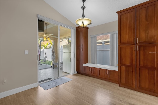 doorway featuring ceiling fan, lofted ceiling, and light hardwood / wood-style flooring