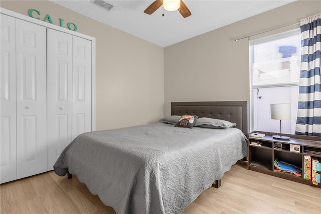 bedroom with light hardwood / wood-style flooring, a closet, and ceiling fan