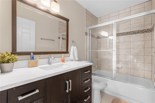 full bathroom featuring vanity, tile patterned flooring, bath / shower combo with glass door, and toilet