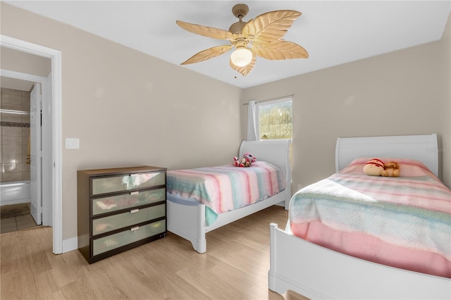 bedroom with ensuite bathroom, ceiling fan, and light hardwood / wood-style floors