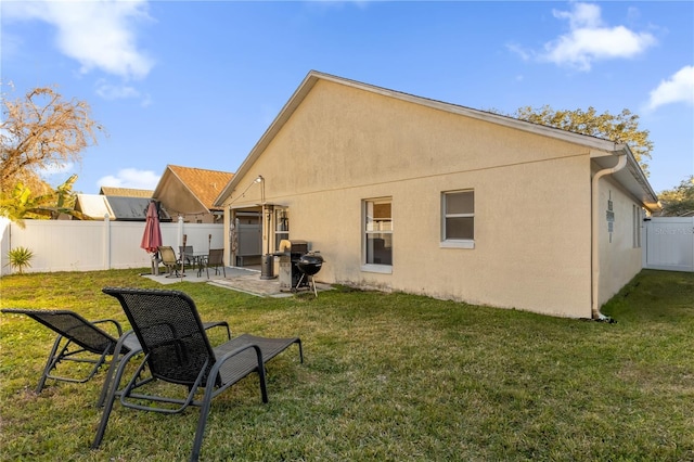 rear view of house featuring a patio and a lawn