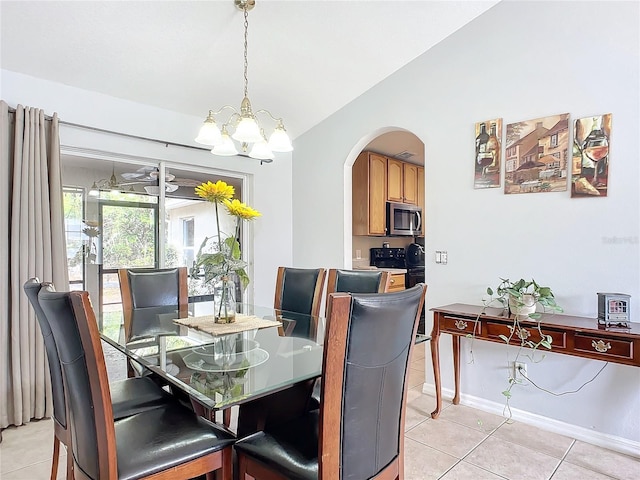 tiled dining area featuring vaulted ceiling and a chandelier