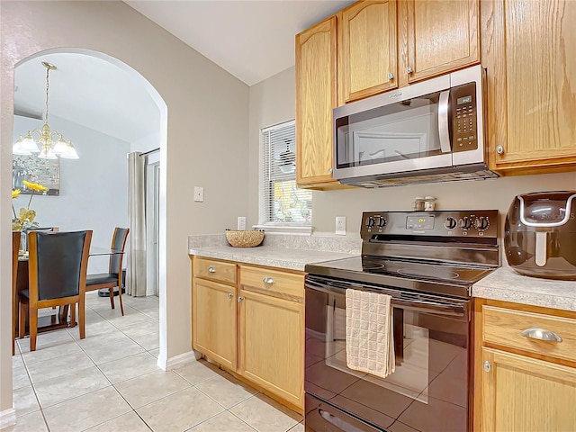 kitchen with light brown cabinetry, black electric range oven, decorative light fixtures, vaulted ceiling, and light tile patterned floors