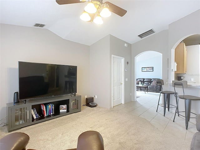 carpeted living room featuring ceiling fan and vaulted ceiling