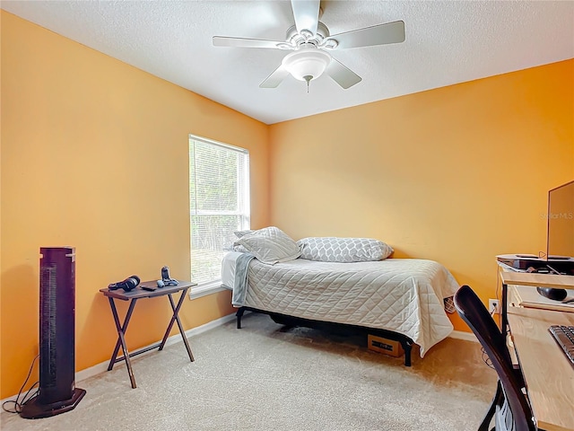 carpeted bedroom featuring ceiling fan and a textured ceiling