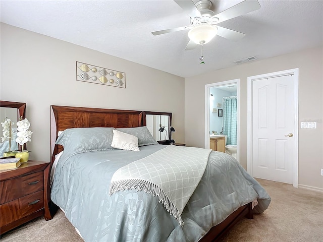 carpeted bedroom featuring ceiling fan, connected bathroom, and a textured ceiling