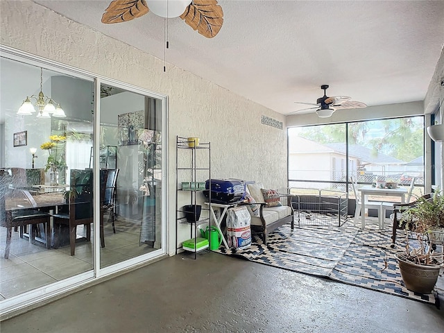 sunroom with ceiling fan with notable chandelier